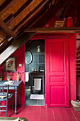 Bright red sliding door to ensuite bathroom in French farmhouse
