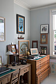 Wooden storage drawers with wooden desk and artwork in study of Oxfordshire home England UK