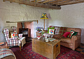 Holzkiste mit Sessel und Sofa im Wohnzimmer eines Cottage in Ceredigion, Wales UK