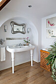 White ceramic washbasin in arched recess of London bathroom, UK