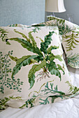 Leaf patterned cushion in bedroom of London townhouse, England, UK