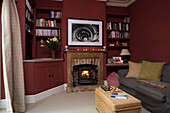 Graues Sofa am offenen Kamin im Wohnzimmer mit eingelassenen Regalen in Shoreham by Sea home West Susses England UK