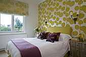 Blättermustertapete mit passenden Jalousien in einem Doppelschlafzimmer in einer britischen Wohnung