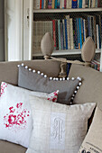 Linen cushions on sofa with bookcase in Hertfordshire living room,  England,  UK