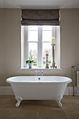 Classic freestanding bath at window of Surrey home,  England,  UK