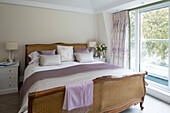 Wicker double bed at window of London home   England   UK