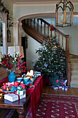 Weihnachtsbaum mit brennenden Kerzen auf einem Tisch im Flur in einem Haus in Sussex, England, Vereinigtes Königreich