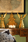 Gold angles and lit candles on inlaid desk  with map in Sussex home  England  UK