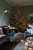 Angezündete Kerzen mit Lichterketten am Weihnachtsbaum im Wohnzimmer King's Lynn Norfolk England UK