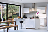 Weiße offene Wohnküche mit großen Fenstern in einem Haus in London, England, UK