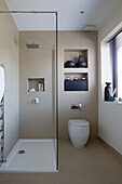 Shower cubicle with recessed shelving in zen styled bathroom interior of London home,  England,  UK