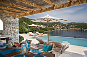 Schattiger Essbereich am Pool mit Sonnenschirmen in einer Villa in der Ägäis, Ithaka, Griechenland
