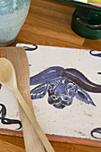 Wooden spoons and hand painted tile in Surrey kitchen England UK