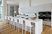 White barstools at breakfast bar in Lechlade kitchen Gloucestershire England UK