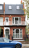 Blaues Auto vor einem viktorianischen Doppelhaus aus Backstein in South West London UK