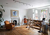 Cello und Sessel mit Werkbank und Hocker in einem Haus in Arundel, West Sussex, England, Vereinigtes Königreich