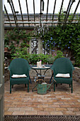 Paar tealfarbene Sessel mit Gießkanne im Wintergarten von Arundel, West Sussex England UK