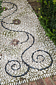 Verschlungenes Muster auf einem Steinweg im Garten von Arundel, West Sussex, England, Vereinigtes Königreich