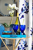 Blaue Gläser und Orchidee mit Weißwein auf Beistelltisch in Londoner Stadthaus UK