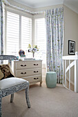 Up-cycled chair and chest of drawers in bay window of London townhouse UK