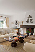 Candle holders and books on dark wood coffee table in living room of Var farmhouse Provence France