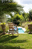 Geflechtsessel im Schatten einer Palme am Pool in Var Provence Frankreich