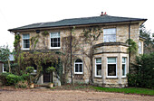 Erkerfenster und Einfahrt an der Außenseite eines Einfamilienhauses aus Stein Surrey, Großbritannien