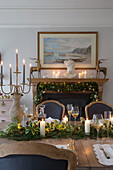 Lit candles and wineglasses on dining table in Surrey home England UK