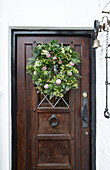 Weihnachtskranz an hölzerner Haustür in Kent England UK