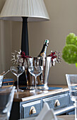 Icebucket and glasses with lamp on sideboard in London townhouse apartment UK