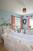 Bunting and floral garlands in girls bedroom in 19th century Somerset cottage England UK