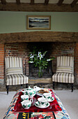 Teaset on tray with pair of upholstered chairs in Kent farmhouse UK