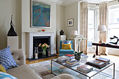 Modern artwork with orchid and books in living room of Victorian terraced house London England UK