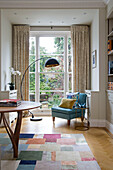 Schwarze Lampe und Stuhl am Gartenfenster in viktorianischem Reihenhaus London England UK