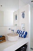 Waschbecken und gestreifte Handtücher unter großem Spiegel in einer Villa in Ithaka, Griechenland