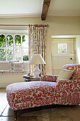 Red upholstered recliner and window with seat in Gloucestershire farmhouse England UK
