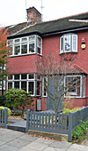 Grey picket fence surrounds front garden of semi-detached London home England UK