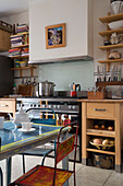 Saucepan on hob with books on shelving in London kitchen England UK