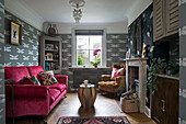 Pink sofa with corner cabinet and dragonfly wallpaper in Sussex home England UK