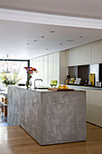 Polierte Kücheninsel aus Beton in offenem Split-Level-Stadthaus in London England UK
