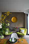 Cut flowers at place setting with pair of lime green chairs in modern London townhouse England UK
