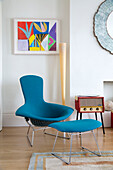 Hellblauer Sessel und Fußhocker mit modernem Kunstwerk in einem Londoner Stadthaus, England, UK