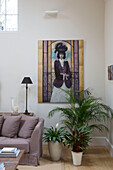 Houseplants and large artworks in living room corner of Gloucestershire farmhouse England UK