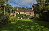 Shadows on lawn in garden of detached Gloucestershire cottage UK
