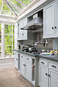 Hellgraue Einbauküche mit Dunstabzugshaube aus Edelstahl in der Küche eines Londoner Stadthauses UK