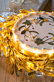 Iced Christmas cake with lit fairylights in Kent country house England UK