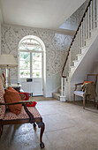 Patterned wallpaper and flagstone floor in spacious Georgian hallway Northamptonshire England UK