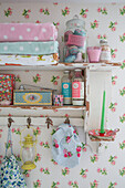 Gefaltete Handtücher, Seifen und Toilettenartikel auf einem Wandregal in einem Cottage-Badezimmer in Kidderminster, Worcestershire, England, UK