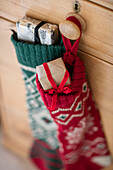 Christmas stockings hang with gifts on wooden drawer handle in Berkshire home UK