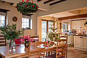 Blattarrangement auf einem hölzernen Esstisch mit Weihnachtsbaum in einem Haus in Berkshire UK